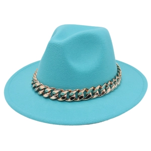 Detail of teal wool fedora hat featuring a chunky gold acrylic chain embellishment