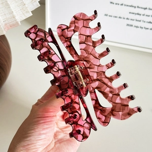 Handheld butterfly hair claw clip in purple tortoiseshell acetate with gold metal spring