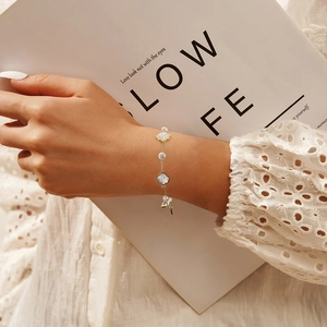 Elegant 925 sterling silver bracelet with baroque pearls and white shell charms on model