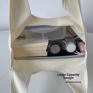 Detailed top view of a cream canvas tote bag showing its large storage capacity with daily items