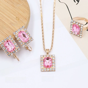 Detailed view of pink crystal jewelry set with gold plating and sparkling accents