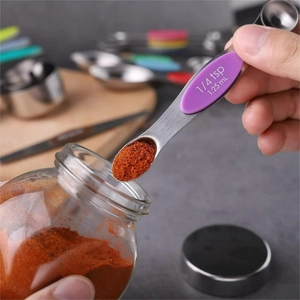 Stainless steel 1/4 tsp measuring spoon with purple handle and red powder