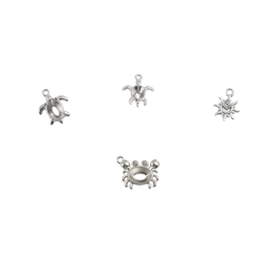 Macro shot of silver stainless steel sea turtle sun and crab pendants for DIY jewelry