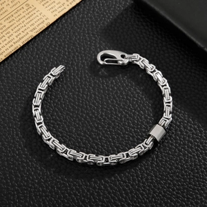 Close-up of Byzantine stainless steel chain with carabiner clasp on black leather