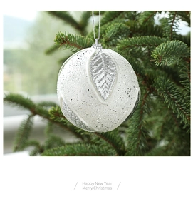 Detail of white 8cm Christmas foam ball with silver glitter leaf texture on a tree