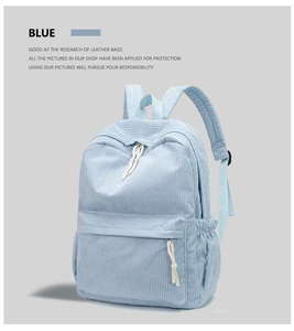 Detail view of a light blue corduroy backpack with white rope zippers in a 45-degree angle