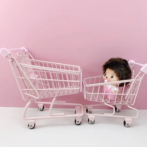 Detailed close-up of two pink mini metal shopping carts for desktop storage and organization