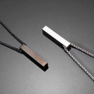 Close-up of polished black and silver stainless steel vertical bar pendant necklaces