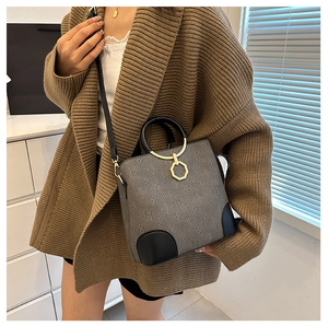 Detail of grey monogram tote bag with gold polygonal ring and black leather corners