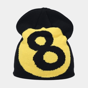 Close-up of thick knit texture and yellow number 8 ball pattern on black beanie