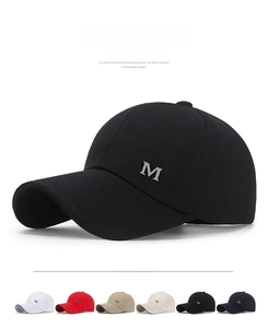 Detail of multi-color canvas baseball caps featuring a metal M logo and long visors