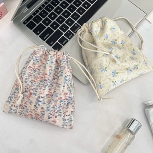 Detail of floral and daisy corduroy drawstring pouches for skincare storage
