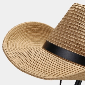 Close-up of the woven texture and black leather belt detail on this Western straw sun hat