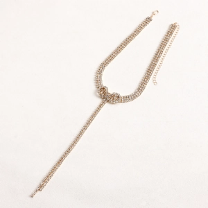 Detailed macro view of triple-row rhinestone gold choker with elegant crystal tassel knot