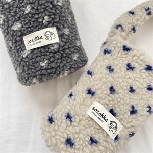 Detail of plush polka dot cup sleeves with cute cartoon dog patches and soft texture