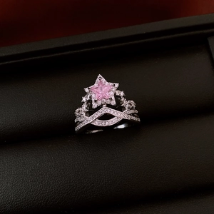 Nahaufnahme eines sternförmigen rosa Edelsteinrings in einer schwarzen Schmuckschatulle