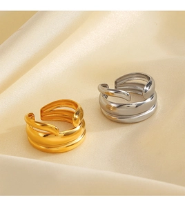 Detail of adjustable layered rings in gold and silver finish on silk fabric
