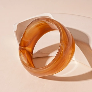 Detailed texture of amber marble acrylic bangle with minimalist resin finish