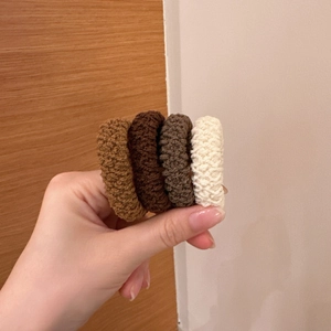 Detailed view of 4 high-elastic braided hair ties in brown and cream neutral tones