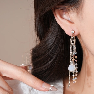 Vue rapprochée de boucles d'oreilles en argent avec opale en goutte et pompons perlés