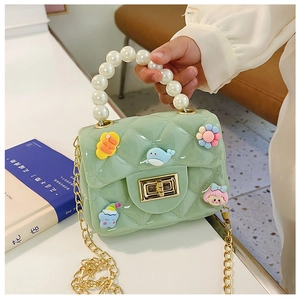 Detail of mint green jelly bag with faux pearl handle and cute decorative charms