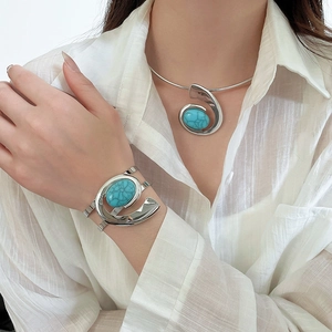 Close-up of silver metal choker and bangle set with oval turquoise stones on model