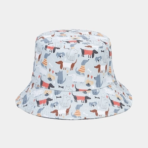 Close-up of reversible bucket hat featuring light blue fabric with cartoon dog patterns