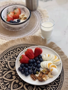 Dettaglio della tovaglietta rotonda in iuta intrecciata sotto colazione e frutta
