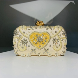 Detailed embroidery on evening clutch featuring beads, crystals, and a yellow heart design