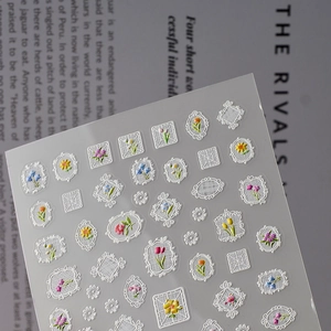 Macro detail of 3D embossed lace frames and colorful floral patterns on nail art stickers