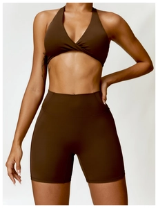 Detail of a dark brown sports set showing the twist-front bra and high-waist yoga shorts