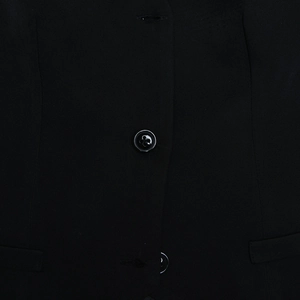 Gros plan d'un bouton noir à quatre trous et de la texture du tissu sur la jupe