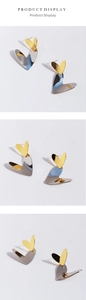 Detail of two-tone gold and silver heart earrings with a polished mirror finish
