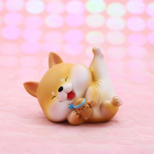 Detail of cute resin Shiba Inu figurine lying with a small peanut character ornament