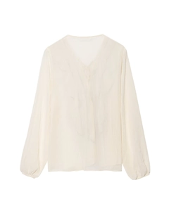 Dettaglio della camicetta con volant e scollo a V in chiffon bianco sporco