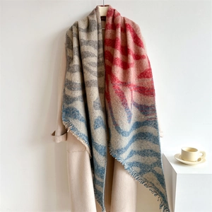 Écharpe à motif zèbre avec franges, élégamment drapée sur un manteau beige minimaliste