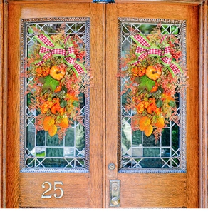 Symmetric autumn wreaths with pumpkins and maple leaves on vintage wooden double doors