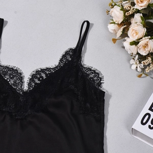 Flat lay of black satin camisole featuring delicate eyelash lace and asymmetric hem detail