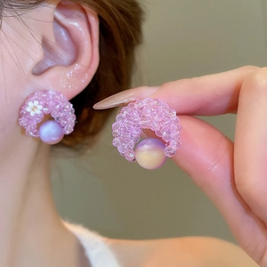 Detail of purple beaded flower earring with pearl drop shown on model and hand