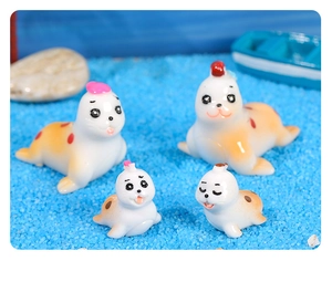 Detailed macro view of four miniature resin seals on blue sand with seashells