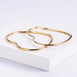 Minimalist large heart-shaped gold hoop earrings made of polished stainless steel