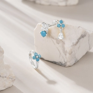 Close-up of S925 sterling silver earring set with turquoise petals and water drop details