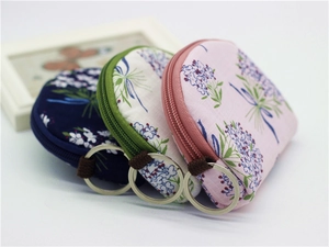 Detailed view of semi-circular floral fabric coin purses with zippers and key rings