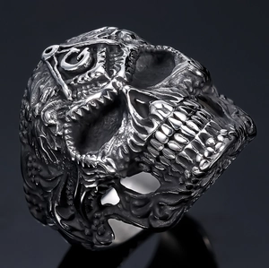 Macro shot of punk style skull ring with Freemasonry square and compass engraving