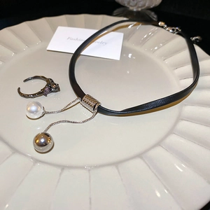 Detail of vintage squirrel jewelry set with zircon pearl on a ceramic tray