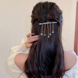French elegant hair clip with artificial crystals and cascading metal tassels in hair