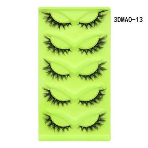 Detailed close-up of 5 pairs of cat-eye false eyelashes in a neon green tray