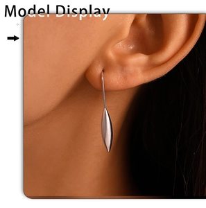 Close-up of elegant silver teardrop earrings worn by a model in a minimalist style