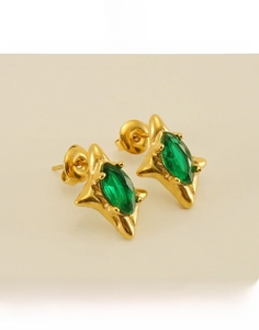 Macro detail of star-shaped 18k gold plated titanium earrings with green zircon gems