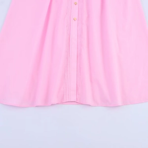 Detailed view of pink midi dress hem featuring vertical pleats and gold metal buttons